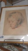 A framed and glazed pastel portrait of a young child.