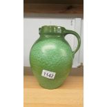 A green pottery jug marked Liberty, Made in England,