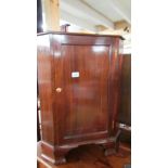 A mahogany corner cupboard with string inlay.
