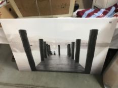 A large unframed painting of a slipway on a river