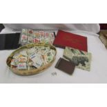 An album containing cigarette cards, an empty album and a tin of assorted cards.