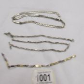 A silver chain (37 grams),another silver chain (20 grams) and a white and yellow metal bracelet.