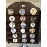 A wooden rack of small decorative plates of the World
