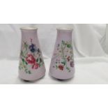A pair of possibly French porcelain bases on three feet in lilac and decorated with flowers and