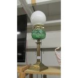 A brass oil lamp with green glass font (converted to electric through burner so easily converted