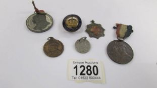 A silver fob, 4 medallions and a badge.