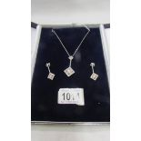 An 18ct white gold and diamond pendant necklace with matching earrings.