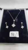 An 18ct white gold and diamond pendant necklace with matching earrings.