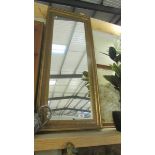 A tall gilt framed mirror.