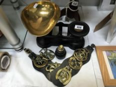 A set of kitchen scales with weights & a quantity of horse brasses