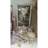 A framed and glazed shell collage and a quantity of sea shells.