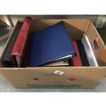 A box of various empty stamp albums