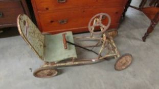 A four wheel pedal car in need of restoration.