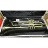 A cased Besson Scolastic trumpet. Has some dents and plate loss and missing mouth piece.