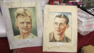 2 unframed pastel portraits of a man and a woman.