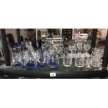 A shelf of good cut glass and blue tinted glassware