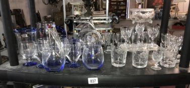 A shelf of good cut glass and blue tinted glassware