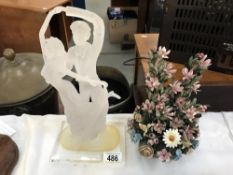 An acrylic dancers figure and a ceramic floral decoration.