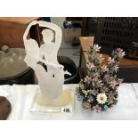 An acrylic dancers figure and a ceramic floral decoration.