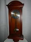 A modern mahogany wall clock in good condition,.