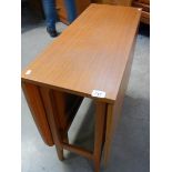 A teak effect drop leaf table with melamine edges, 83 x 34 cm closed, 150 x 83 cm open.