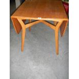 An oak drop leaf dining table in the style of Ercol, 75 x 84 cm closed, 138 x 84 cm open.