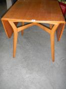 An oak drop leaf dining table in the style of Ercol, 75 x 84 cm closed, 138 x 84 cm open.