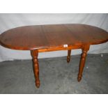 An oval teak extending table, 127 cm (open), 110 cm (closed) x 80 x 74 cm.