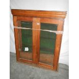 A glass fronted 2 door cabinet with shelves (glass needs replacing) 115 x 98 x 30 cm.