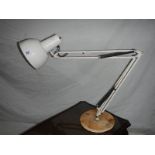 A large white angle poise lamp with weighted bottom.