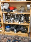 3 shelves of assorted kitchen ware including saucepans etc.