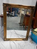 A gilt framed bevel edged mirror, 75 x 106 cm.