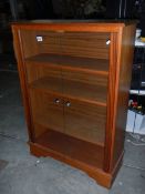 A teak 2 door cabinet with glass doors.