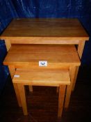 A nest of 3 pine tables in good condition.