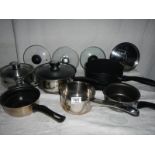 A mixed lot of clean saucepans, some with lids and some spare lids.