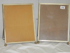 A pair of early 20th century photo frames with easel stands made by Simple Simon Co., 34 cm x 26 cm.