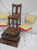 A tall straight backed chair, 2 1960's vinyl chairs and 3 vintage suitcases.