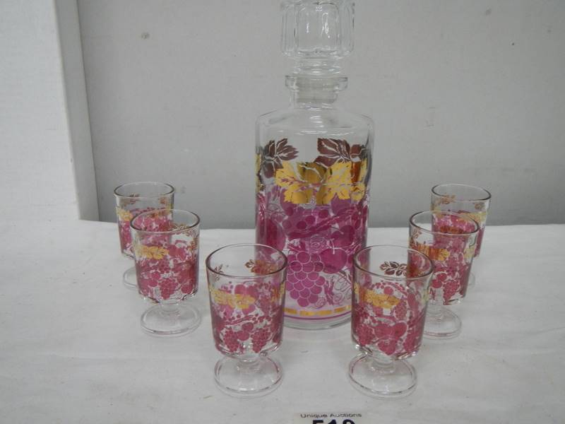 A mid 20th century boxed decanter and glass set decorated with red and gold transfers.