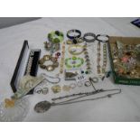 A mixed lot of costume jewellery including necklaces, bangles, rings etc and a small clock.