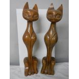 A pair of tall wooden cat figures.