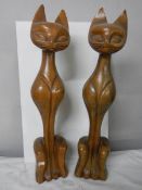 A pair of tall wooden cat figures.