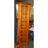 A tall modern pine corner cabinet in excellent condition.