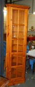 A tall modern pine corner cabinet in excellent condition.