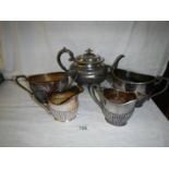 A pewter teapot, 2 sugar bowls and 2 milk jugs.