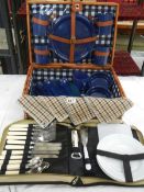 A picnic basket with contents and cutlery.