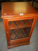 A lead glazed single door cabinet.