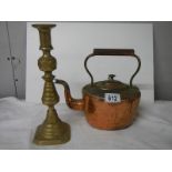 A Victorian copper kettle and a brass candlestick.