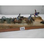 A diorama featuring 4 horses pulling a cannon and soldiers on horseback.