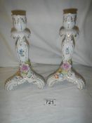 A pair of continental porcelain candlesticks, in good condition.