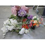 A quantity of artificial flowers, some with vases.